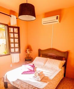 a bedroom with a bed and a air conditioner at Pousada Casa do Oscar in Governador Celso Ramos