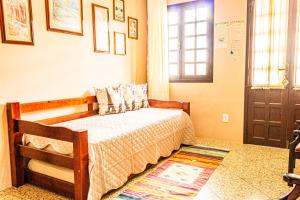a bedroom with a bed and a window and a door at Pousada Casa do Oscar in Governador Celso Ramos