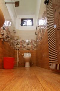 a bathroom with a toilet and a window on the wall at Royal Holidays in Alleppey