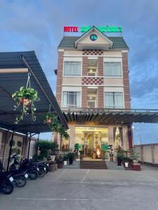 朔莊的住宿－XUÂN HUỲNH 3 Hotel，一辆摩托车停在酒店前面的酒店