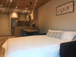 a bedroom with a large white bed and a table at Apartamento de Alicia in Betrén