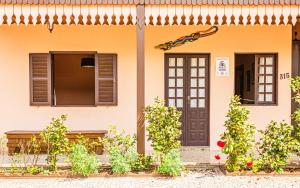 a house with two windows and a door at Pousada Casa do Oscar in Governador Celso Ramos