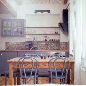 a kitchen with a wooden table with four chairs at Penzion Venkoff in Sázava