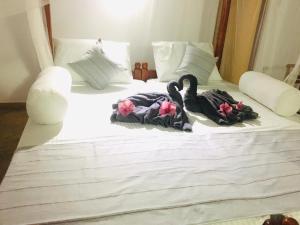 two swans towels are sitting on a bed at Dilena Beach Inn in Tangalle