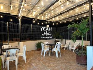 a restaurant with white chairs and tables and a sign at Bungalows Yeah Los Ayala in Los Ayala