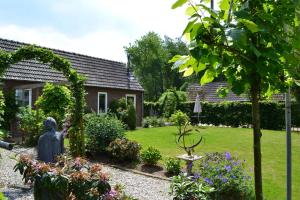 einen Garten mit einer Statue in der Mitte eines Gartens in der Unterkunft Appartement De Bosuil in Groesbeek