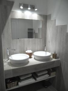 a bathroom with two sinks and a mirror at Le Clos d'Isabelle in Marsillargues