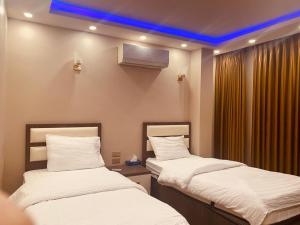 2 letti in una camera con soffitto blu di Seven Days Hotel a Irbid