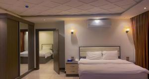 Cette chambre comprend 2 lits et un miroir. dans l'établissement Seven Days Hotel, à Irbid