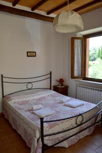 1 dormitorio con 1 cama con 2 toallas en Villa Santa Maria, en Montalcino