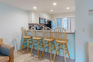 a kitchen with four bar stools and a counter at Villas of Bethany West -- 722C Treetop in Bethany Beach