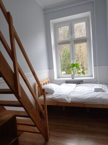 Schlafzimmer mit einem Bett und einem Fenster in der Unterkunft Fiore in Duszniki-Zdrój