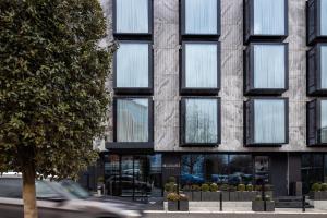 a car driving past a building with windows at Hotel MANAMI in Pristina