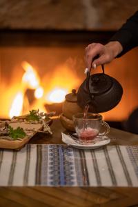 a person is stirring a cup of tea on a table at Limeri Traditional Guest House in Monólithos