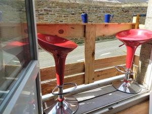 un par de taburetes rojos sentados en una ventana en L'éléphant Blanc de ConcarnOLoc, en Concarneau