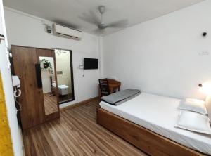 a small room with a bed and a mirror at HOSHTEL99 - Stay, Cowork and Cafe - A Backpackers Hostel in Pune