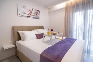 a bedroom with a white bed with a table on it at Petit Palace Trikala in Tríkala