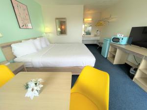 een hotelkamer met een bed en twee gele stoelen bij LuLu Silver City in Silver City
