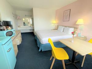 a hotel room with a bed and a table with a yellow chair at LuLu Silver City in Silver City