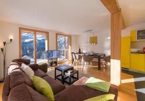 a living room with a couch and a dining room at Chalet Wyssbirg in Wengen