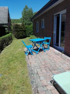 a blue picnic table and two chairs on a brick patio at Gite des Evêts in La Roche-en-Ardenne