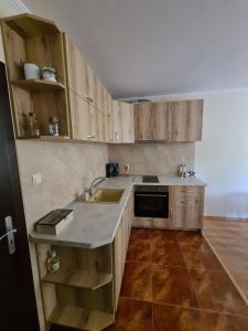 een keuken met houten kasten en een spoelbak bij Родопски Рай in Pamporovo +12 foto's