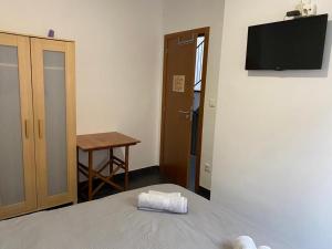 Cette chambre comprend un lit, une table et une télévision. dans l'établissement Casa Rural Xàtiva, à Xàtiva