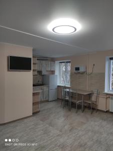 a kitchen and dining room with a table and chairs at Апартаменти центр біля озера in Ternopilʼ