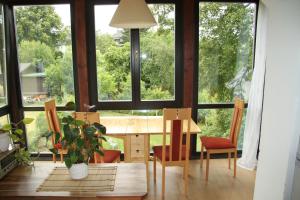 a dining room with a table and chairs and windows at Apartment in Chemnitz, Ebersdorfer Wald in Chemnitz