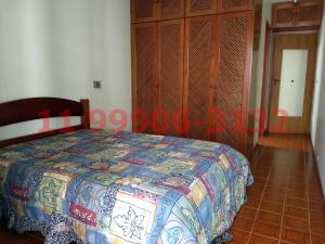 a bedroom with a bed with a colorful quilt on it at Pitangueiras Bárbaro - 2 garagens - 1 diária de 24 horas - Aqui você pode in Guarujá