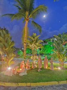 a group of pelicans sitting under a palm tree at night at Nannai Residence Porto Galinhas Praia Muro Alto 101 in Porto De Galinhas