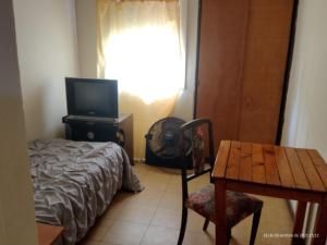 マル・デル・プラタにあるHotel Danteのベッドルーム1室(ベッド1台、テーブル、テーブル、椅子付)