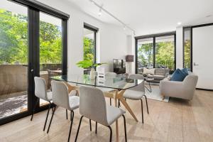 Palmerston St Apartments by Urban Rest في ملبورن: غرفة طعام مع طاولة وكراسي زجاجية