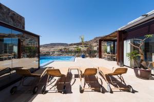 a patio with chairs and a table and a pool at Sunset Villa in La Playa de Tauro