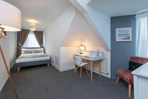 a bedroom with a bed and a desk and a bed and a chair at Spacious apartment with free parking in Weymouth