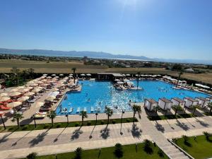 einen Luftblick auf einen Resortpool mit Sonnenschirmen und Stühlen in der Unterkunft Deluxe Resort and SPA in Shkodra