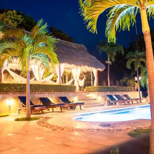 a resort with palm trees and a swimming pool at Nicawaves in Popoyo