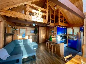 a kitchen and living room with a blue couch in a cabin at Le petit chalet sur le lac in Sainte-Marguerite