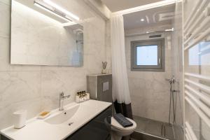 a bathroom with a sink and a toilet and a window at Petit Palace Trikala in Tríkala