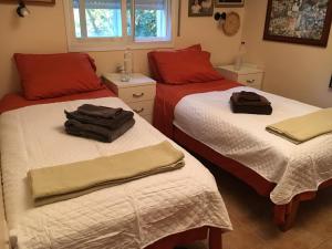 una camera con due letti con cuscini rossi di Dorraine's Jerusalem Bed & Breakfast a Gerusalemme