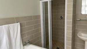 Ikhwezi guest house في شرق لندن: حمام مع دش ومرحاض ومغسلة