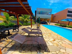 a group of chairs sitting next to a swimming pool at Hotel Imigrantes in São Pedro +12 photos