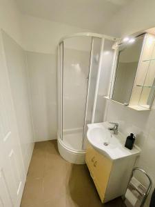 a white bathroom with a shower and a sink at Casa Benke Ház in Covasna +14 photos