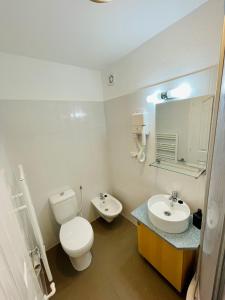 ein weißes Bad mit einem WC und einem Waschbecken in der Unterkunft Casa Benke Ház in Covasna