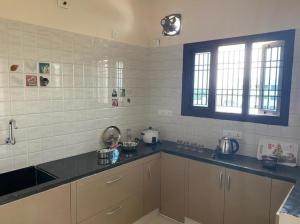 a kitchen with a sink and a counter top at OM SRINIVASA - TRULY HOMESTAY in Tirupati