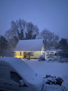 a house with a snow covered roof in a yard at Nordwind Sjut in Warnow