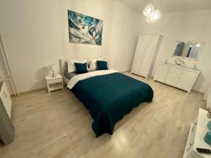 a bedroom with a large bed with a blue blanket at Apartament White in Olsztyn