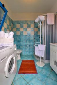 een badkamer met een wasmachine en een toilet bij Antico Trullo Salentino in Salve