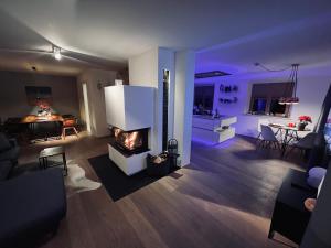 ein Wohnzimmer mit einem Kamin und eine Küche mit einem Tisch in der Unterkunft Hofwies-Exklusiv - Privates Luxus-Boutique Ferienhaus in Miesbach