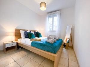 1 dormitorio con cama con sábanas azules y ventana en Blue Pearl - Parking - Gare RER à 5 min, en Corbeil-Essonnes